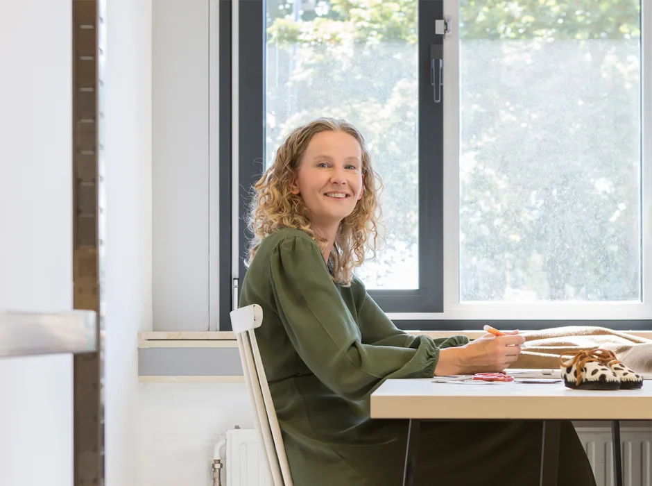 Eigenaar van Mini Pebbles aan haar werktafel bij het raam